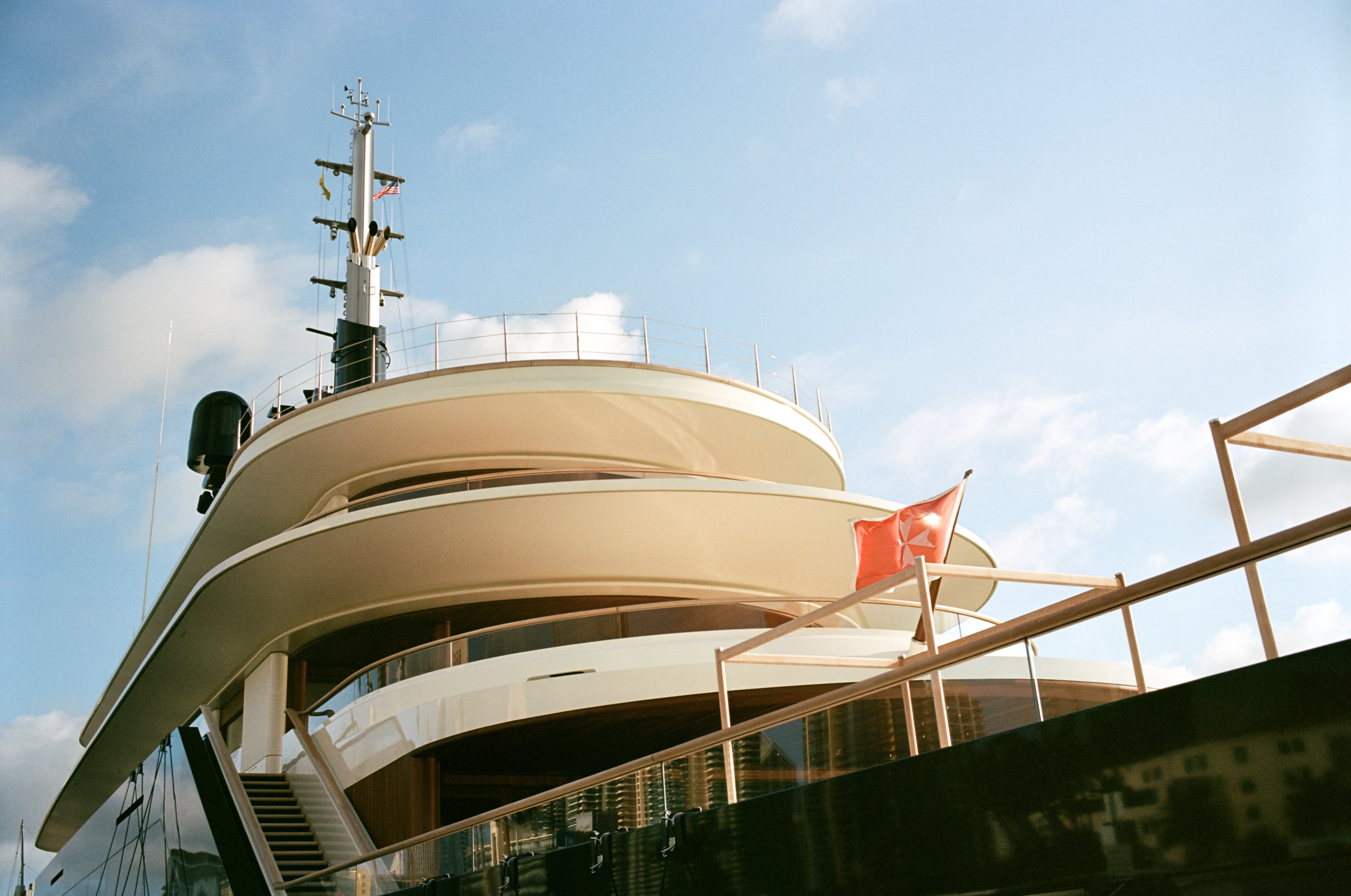 A profile photo of a large yacht with rounded curvature accenting several navigation antennas.