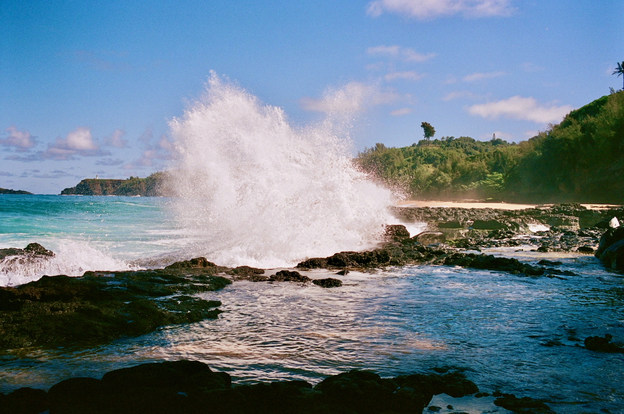 A photograph shows a huge wave crashing into a tide pool.