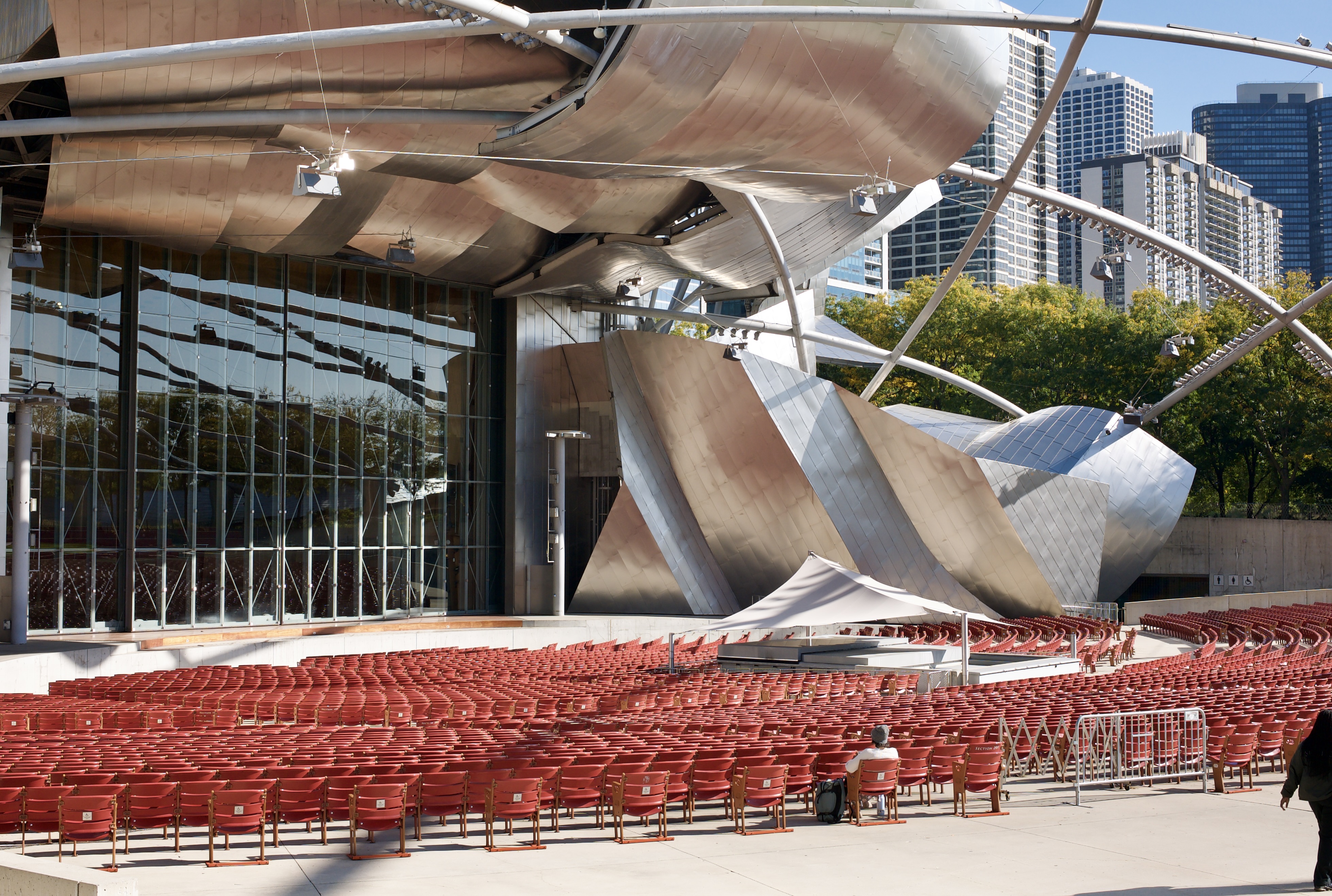 A man sits in an empty audience facing a stage.