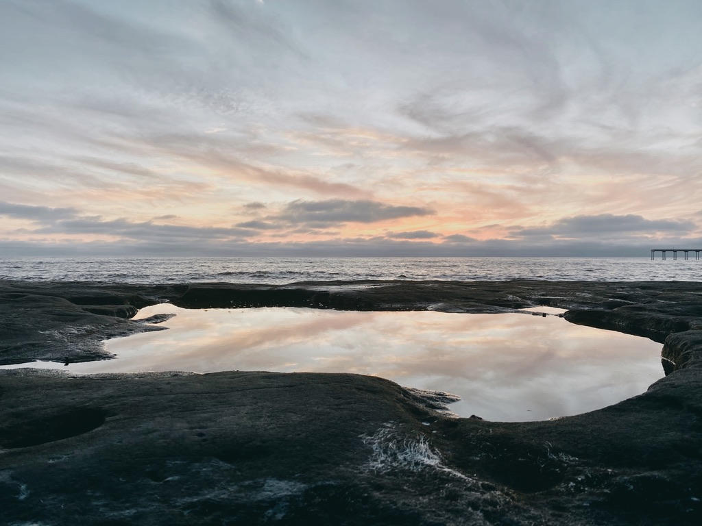 A tidepool reflects the sky in Ocean Beach, California